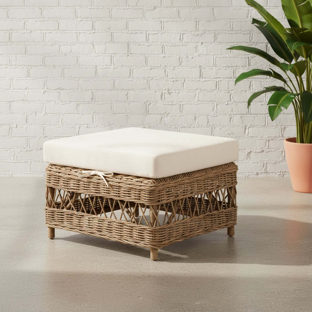 A square rattan ottoman with a white cushion on top.