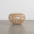 A beige rattan side table with a geometric lattice design and four legs.
